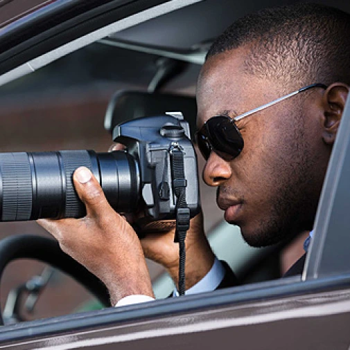 An image showing a professional private investigator diligently conducting surveillance from the privacy of their vehicle.
